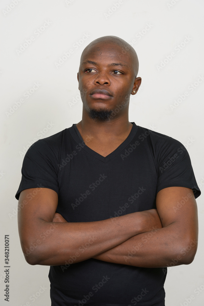 Young handsome bald African man thinking with arms crossed Young handsome bald African man thinking with arms crossed