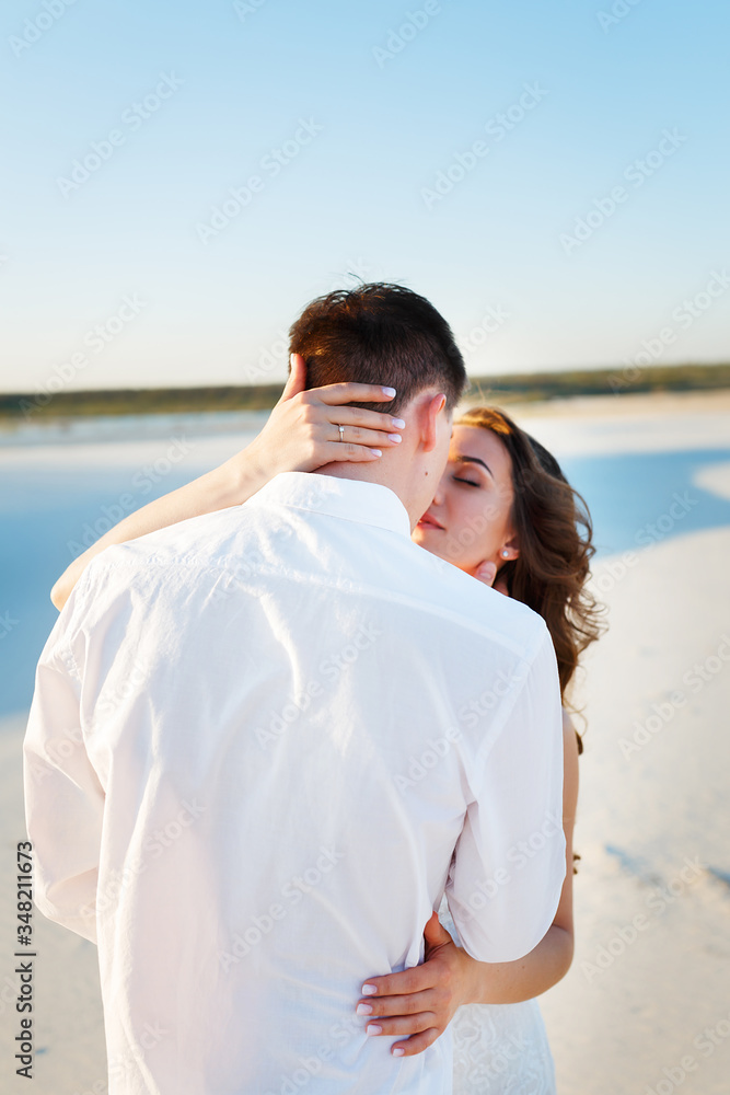 Newlyweds kisses in the desert at sunset