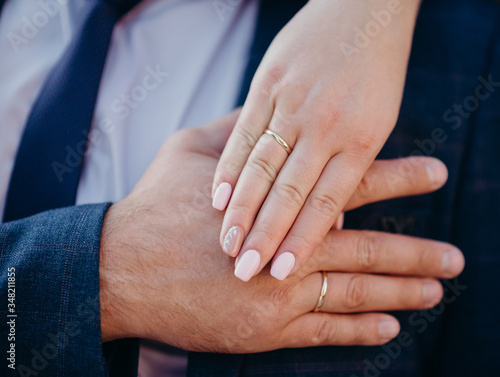 hands of man and woman with wedding rings. Wedding day. Gold rings on the hands of the newlyweds.