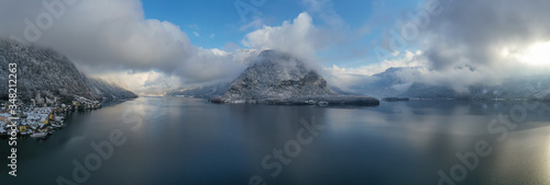 Panorama view of Hallstattersee lake and mountain in daylight with snow. Landscape view of famous Hallstatt lakeside town during winter. Town square in Hallstat. Salzkammergut region, Austria.Jan.2020