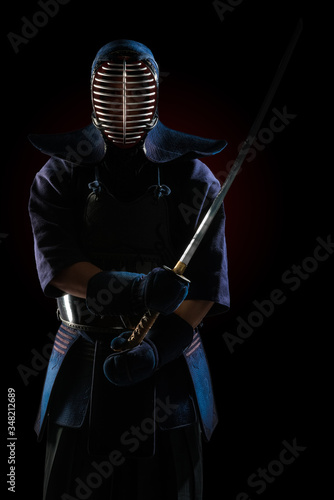 Male in tradition kendo armor with Samurai sword katana. shot in studio. Isolated on black background photo