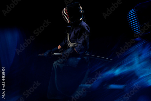 Male in tradition kendo armor with Samurai sword katana. shot in studio. Isolated on black background