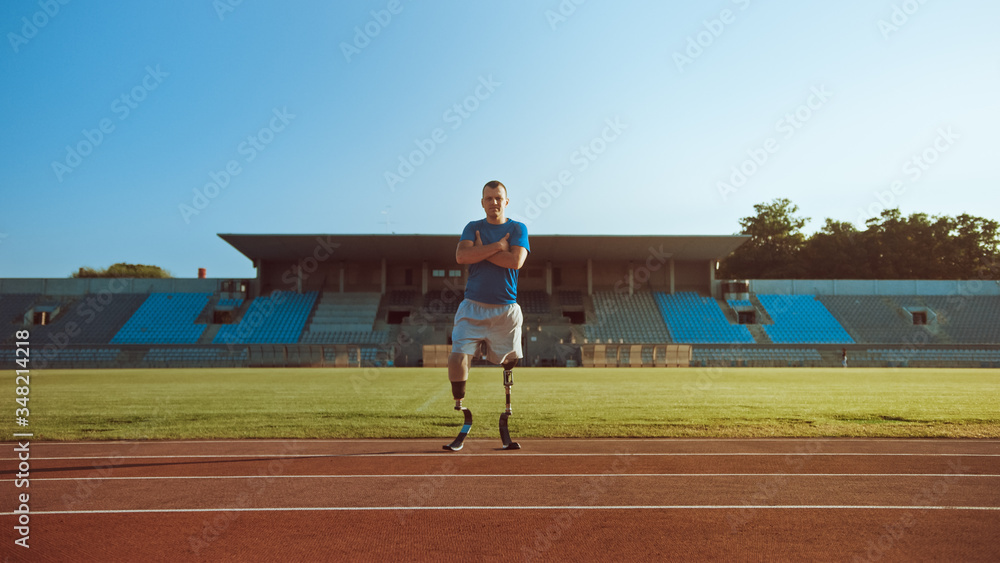 Obraz premium Athletic Disabled Fit Man with Prosthetic Running Blades is Posing with Crossed Arms on an Outdoor Stadium on a Sunny Afternoon. Amputee Runner Standing on a Track. Motivational Sports Shot.
