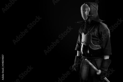 Male in tradition kendo armor with Samurai sword katana. shot in studio. Isolated on black background