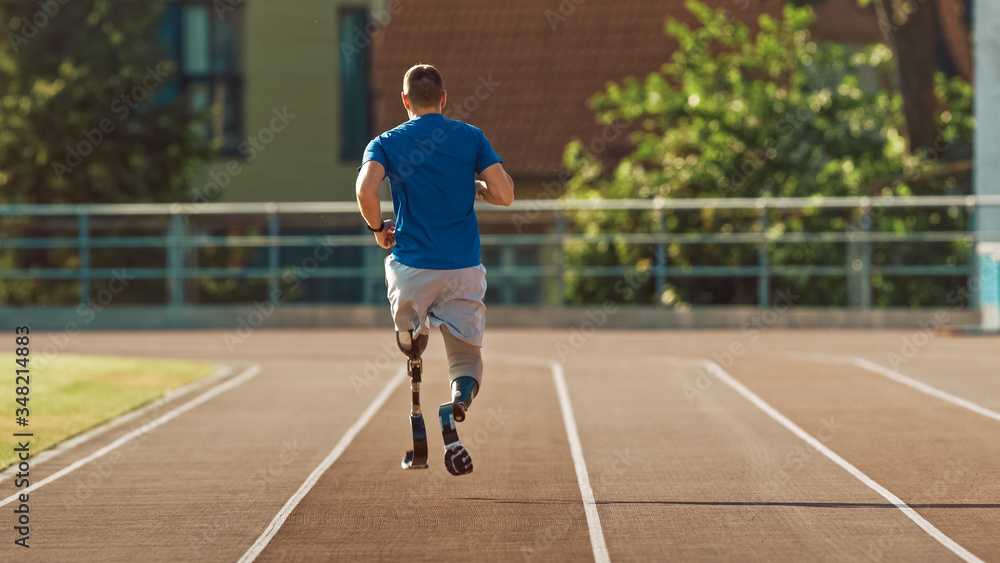 Fototapeta premium Athletic Disabled Fit Man with Prosthetic Running Blades is Training on a Outdoors Stadium on a Sunny Afternoon. Amputee Runner Jogging on a Stadium Track. Motivational Sports Shot.