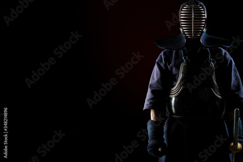 Male in tradition kendo armor with Samurai sword katana. shot in studio. Isolated on black background photo