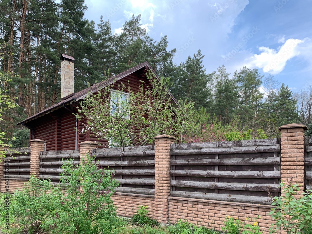 Wooden house on a background of pine forest. A house made of wooden beams in the middle of nature. Mansion in the forest. Wooden house on a background of pine forest. A house made of wooden beams in the middle of nature. Mansion in the forest.