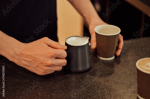 a young man pours coffee in a coffee shop