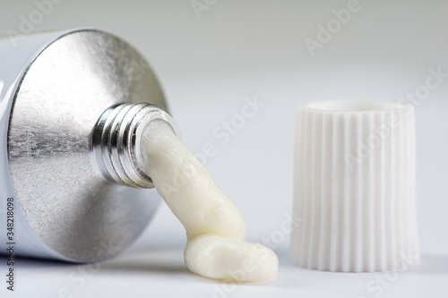 Foto ointment or cream for external use is slightly squeezed out of a tube on a white