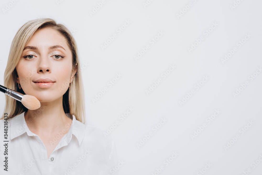 A pretty young woman is using different make-up accessories for application of make-up A pretty young woman is using different make-up accessories for application of make-up