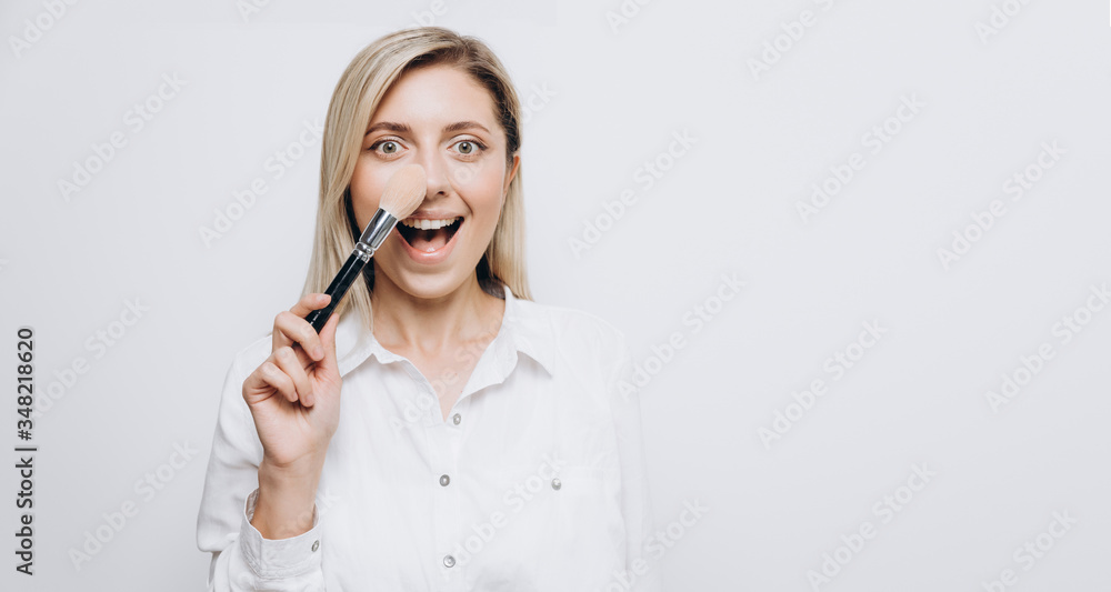 A pretty young woman is using different make-up accessories for application of make-up A pretty young woman is using different make-up accessories for application of make-up
