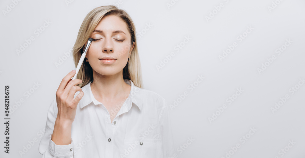 A pretty young woman is using different make-up accessories for application of make-up A pretty young woman is using different make-up accessories for application of make-up