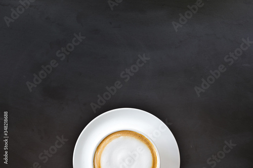 cup of coffee on black wooden floor background. top view