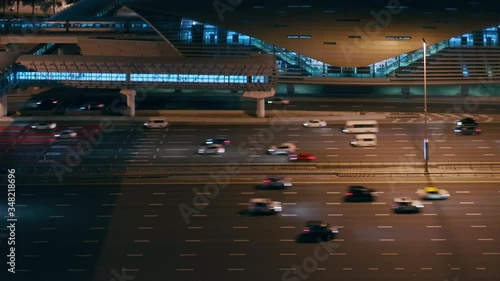 Aerial night view of empty highway and intersection in Dubai after epidemic lockdown. Cityscapes with appearing traffic on streets and metro station. Roads and lanes crossroads without cars, Dubai photo