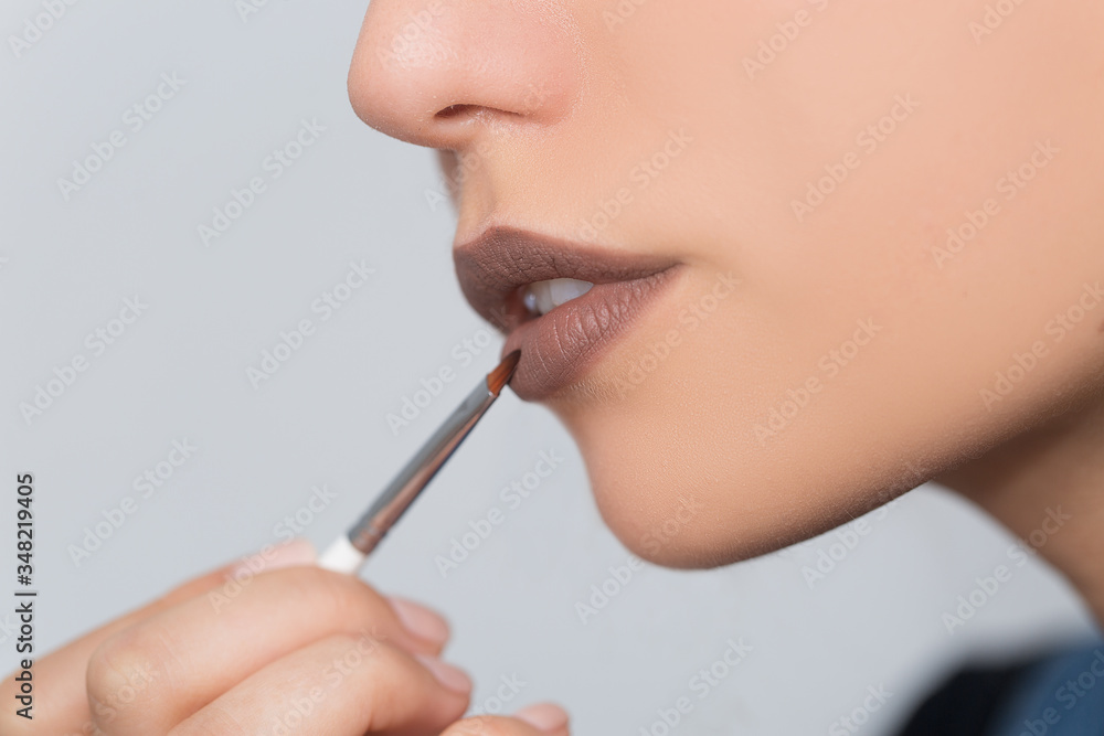 Young beautiful woman lipstick with an applicator