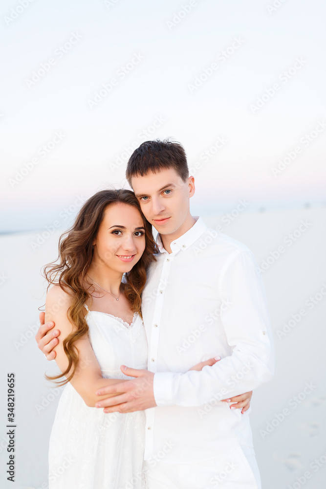 Obraz premium groom hugging bride in the desert at sunset