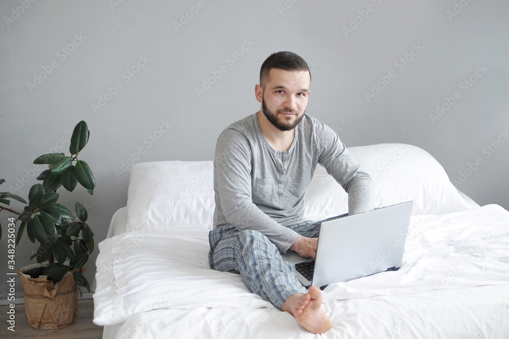 Man in bed works from home. Remote work concept. Man in bed works from home. Remote work concept.
