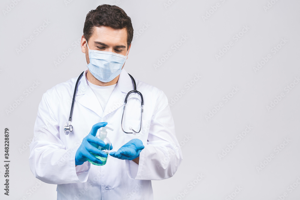 Doctor man in gown face mask gloves isolated on white background. Epidemic pandemic coronavirus 2019-ncov sars covid-19 flu virus. Bottle with alcohol liquid antibacterial sanitizer. Doctor man in gown face mask gloves isolated on white background. Epidemic pandemic coronavirus 2019-ncov sars covid-19 flu virus. Bottle with alcohol liquid antibacterial sanitizer.