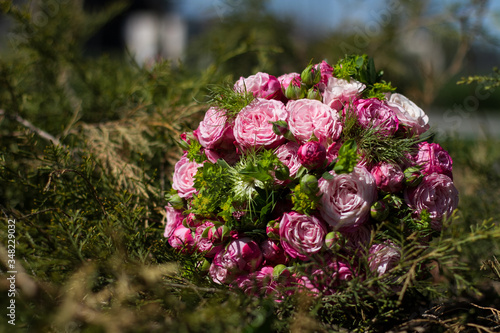 Wedding bouquet of pink roses on a stone with summer background.