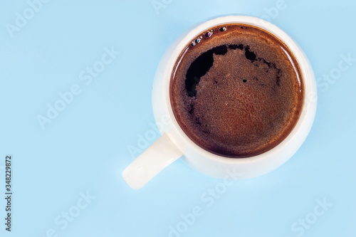 Black coffee in a white mug on a blue background