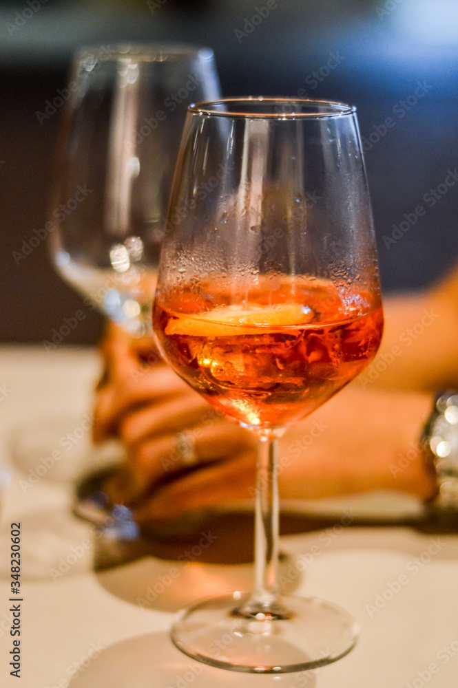 sharing spritz cocktails close up with hands - Spritz is a wine-based cocktail served as an aperitif in Italy. 