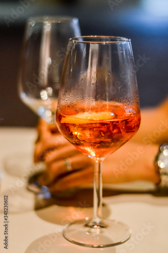 sharing spritz cocktails close up with hands - Spritz is a wine-based cocktail served as an aperitif in Italy. 