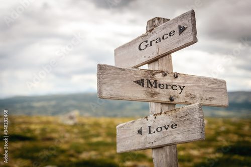 grace mercy love text engraved on old wooden signpost outdoors in nature. Quotes, words and illustration concept photo