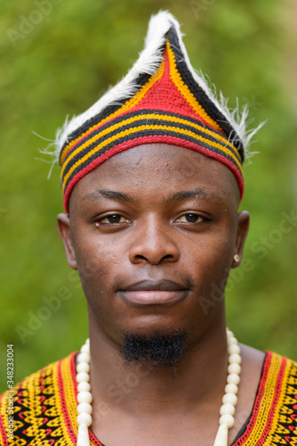 Face of young handsome African man wearing traditional clothing outdoors