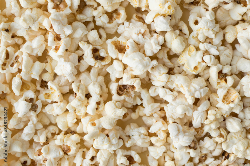 Popcorn grains close-up, close popcorn texture, popcorn on a yellow background Popcorn grains close-up, close popcorn texture, popcorn on a yellow background