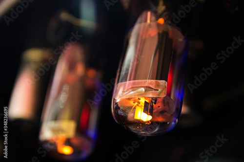 Electrical light buld with purple, yellow, orange light and wire inside on black background. Electron tube. Radio tube. Radio valve. Electric vacuum device isolated on black background. lighting bulb.