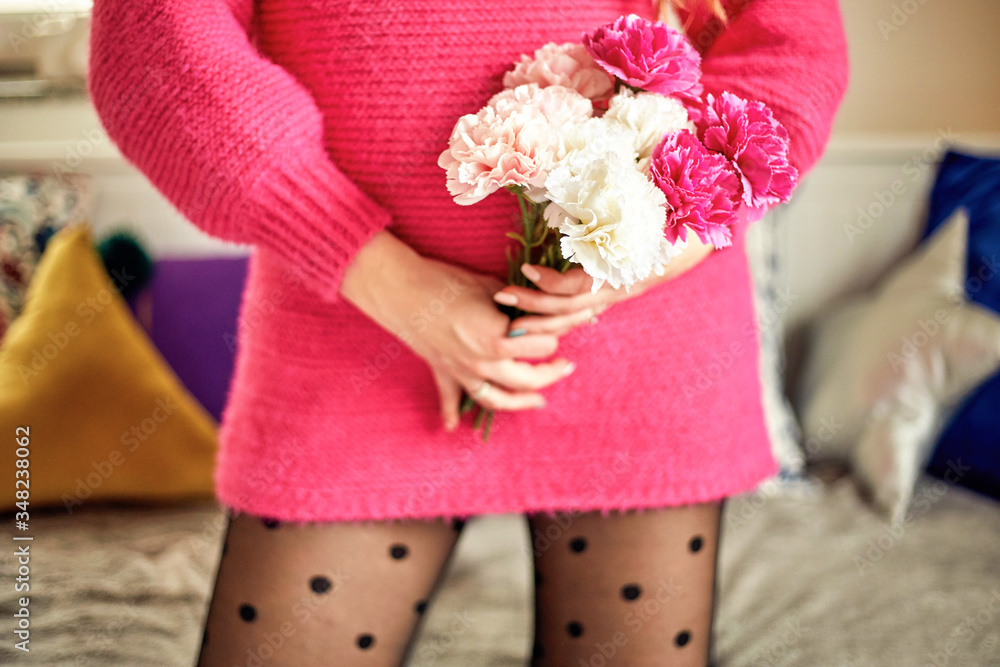 Beautiful pregnant woman holding bouquet of flowers. Focus on hand. Beautiful pregnant woman holding bouquet of flowers. Focus on hand.