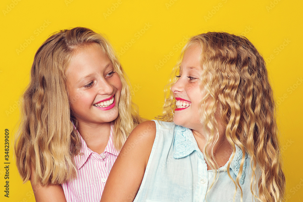 Sisters twins having fun together. Girls posing at studio. Summer, vacation and fashion. Sisters twins having fun together. Girls posing at studio. Summer, vacation and fashion.