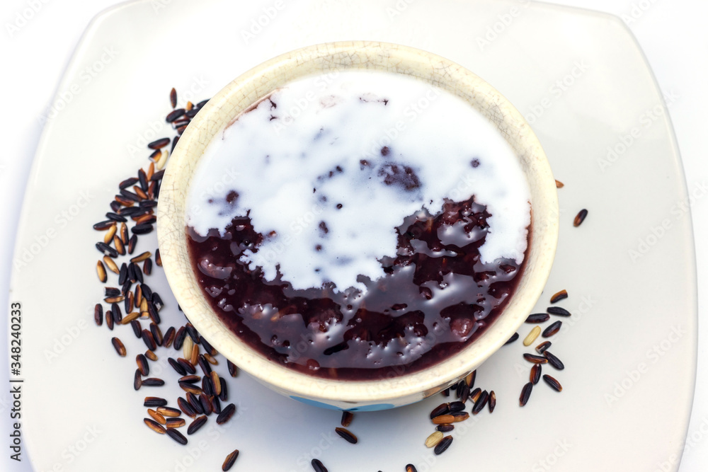 thai black sticky rice wiht sweet coconut milk on top in white plate thai black sticky rice wiht sweet coconut milk on top in white plate
