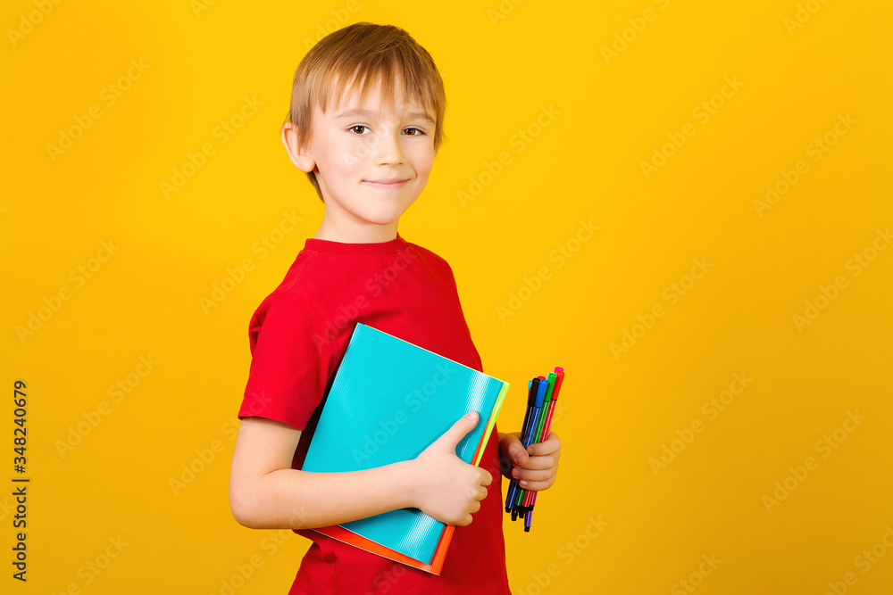 Cute school boy with notebooks on a yellow background. Back to school copcept. Cute school boy with notebooks on a yellow background. Back to school copcept.