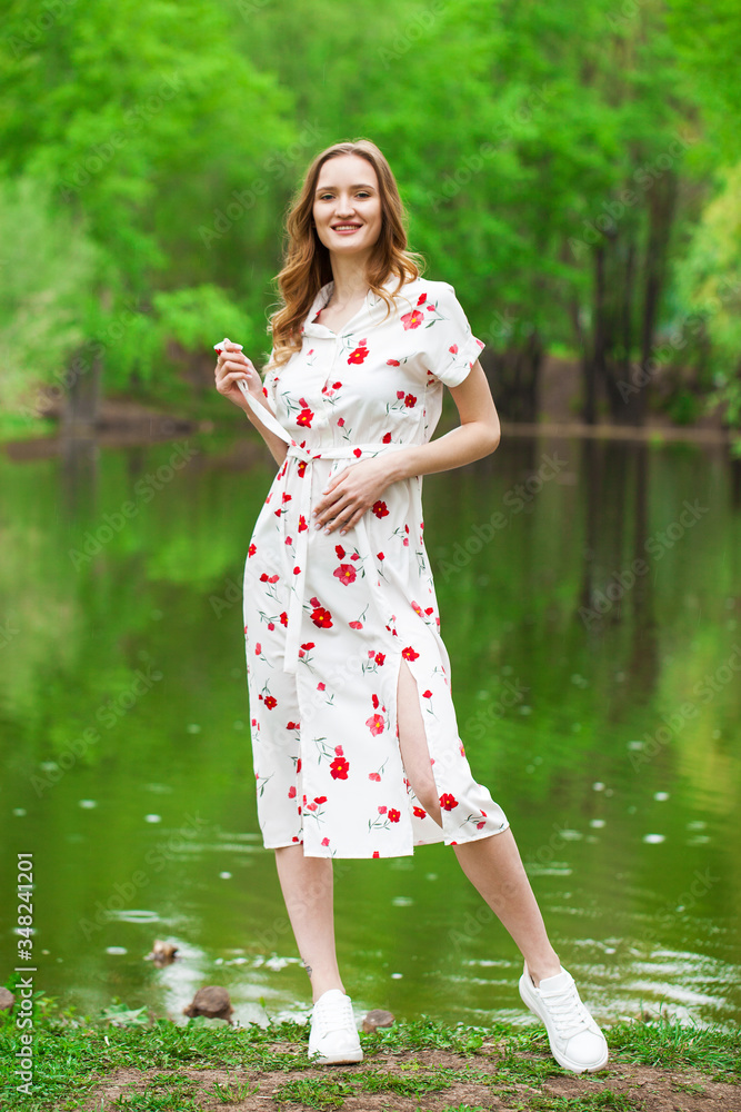 Portrait of a young beautiful woman in white dress posing by the lake Portrait of a young beautiful woman in white dress posing by the lake