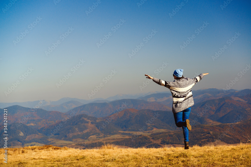 Stylish traveler girl jumping in mountains. Happy hipster woman having fun on top of mountain. Travel, lifestyle and vacation. Stylish traveler girl jumping in mountains. Happy hipster woman having fun on top of mountain. Travel, lifestyle and vacation.