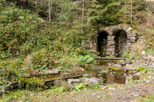 Lost in the forest ancient contstruction in arch form