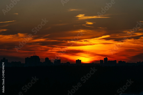 Orange sunset over the city covered by clouds over Minsk, Belarus.