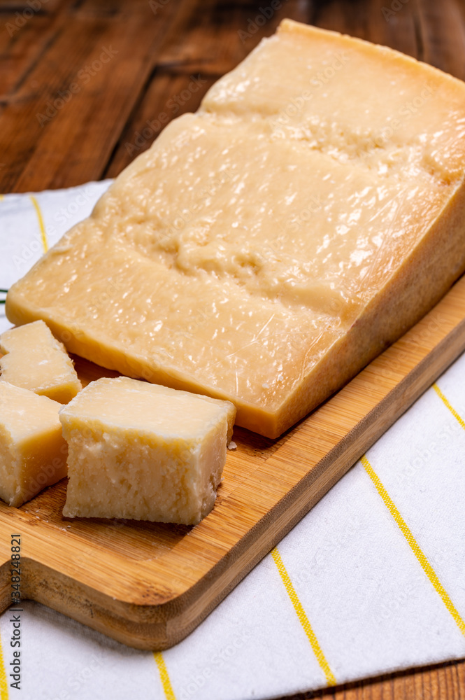Big wedge of parmigiano-reggiano parmesan hard Italian cheese made from cow milk or Grana Padano Big wedge of parmigiano-reggiano parmesan hard Italian cheese made from cow milk or Grana Padano