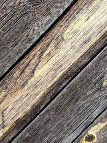 Textured background of a gray aged wooden wall. Textured surface of gray wood closeup. Rough grungy grunge background. Shabby wooden background. Country style. Boards are located diagonally