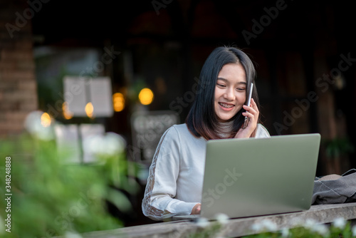 Woman sitting on a computer and having a mobile phone