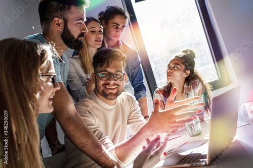 Group of programmers and designers in a conference room. They're discussing development of a new project. 