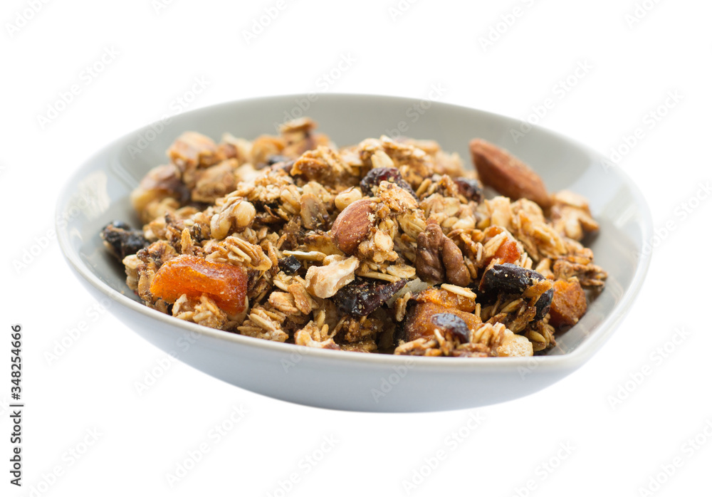 Morning breakfast with granola in a ceramic bowl isolated on white background. Side view. Morning breakfast with granola in a ceramic bowl isolated on white background. Side view.
