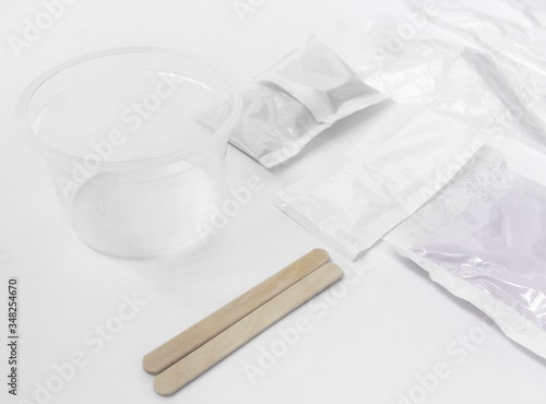 Close up of medical experiments. transparent jar, three pockets with reagents, medical gloves on isolated light background. Experiments for kids. Selective focus
