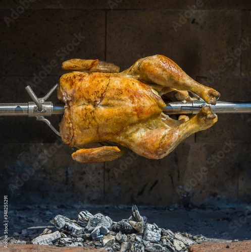 Slowly rotating chicken on a grill.