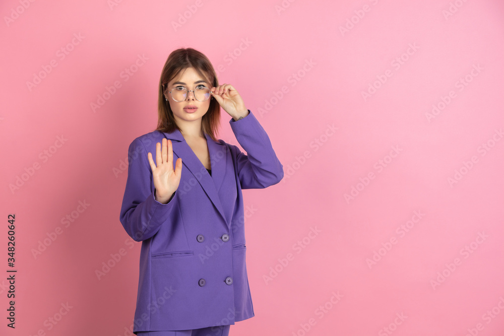 Stoping, rejecting. Caucasian young woman's portrait isolated on pink studio background. Beautiful female model in purple jacket. Concept of human emotions, facial expression, sales, ad. Copyspace. Stoping, rejecting. Caucasian young woman's portrait isolated on pink studio background. Beautiful female model in purple jacket. Concept of human emotions, facial expression, sales, ad. Copyspace.