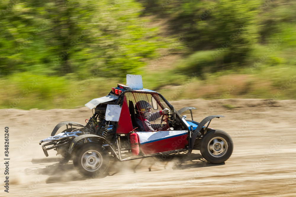 the buggy car is speeding through rough terrain in dusty clubs. The concept of extrieme offroad driving
