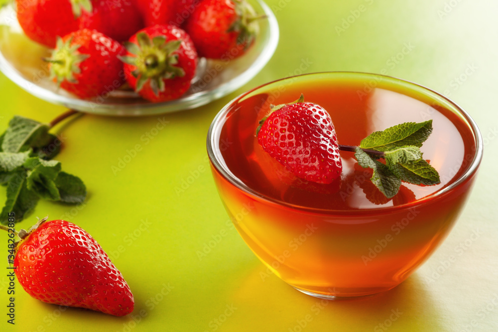 Fruit jelly with strawberries on a green table Fruit jelly with strawberries on a green table