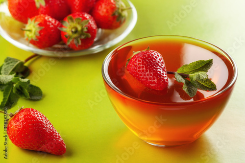 Fruit jelly with strawberries on a green table