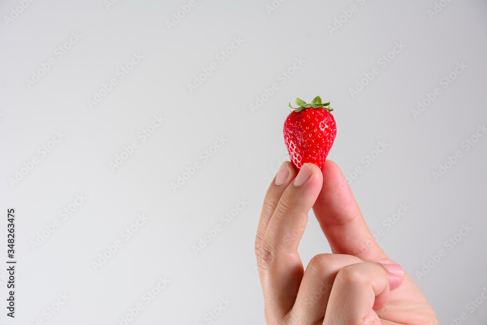 Obraz premium Fresh organic strawberries in mans hand isolated on white background.